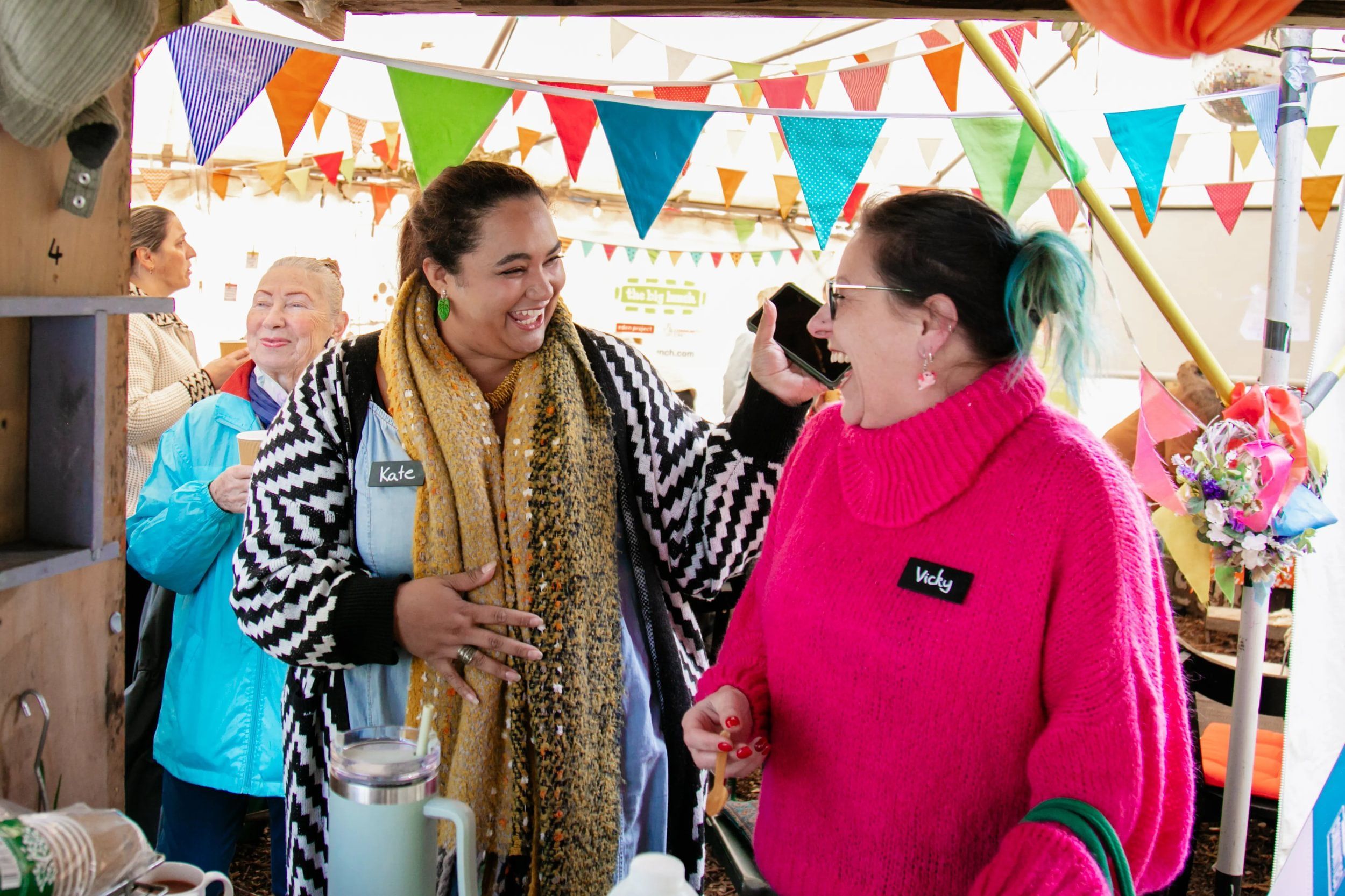 Two women smiling and chatting to each other with name badges on