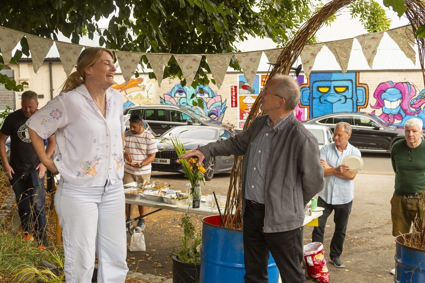 Sophie Macaulay from GRIT Studios Stockport laughs while talking to Michael Osbaldeston from City and Guilds in the GRIT community garden.